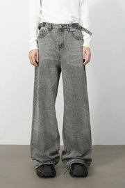 Wide-leg dark gray washed denim jeans with belt and relaxed fit.