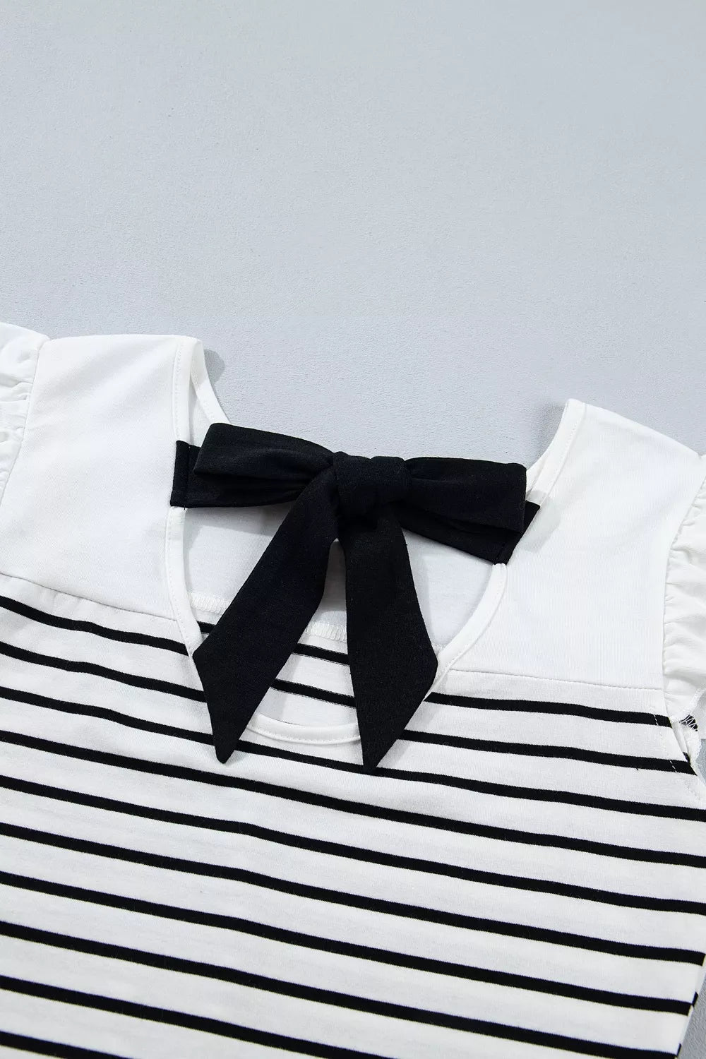 Striped cotton tank top with ruffled sleeves and a black knot back detail.