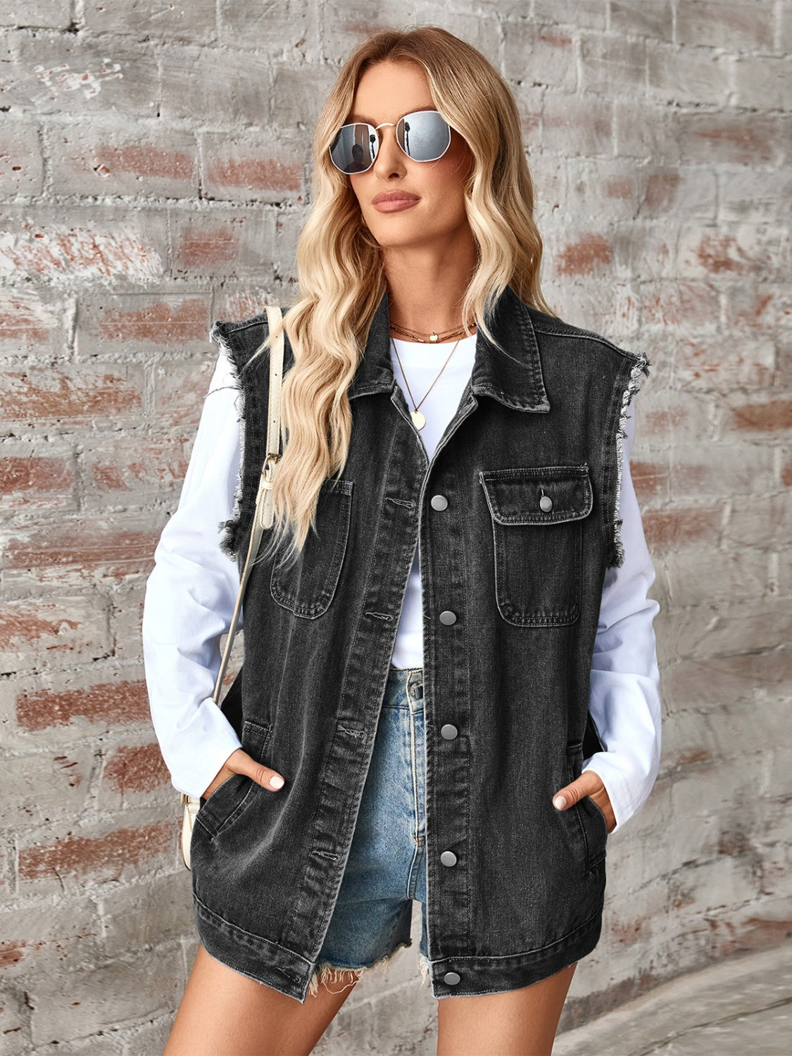 Black denim utility vest with raw edges, button front, and chest pockets.