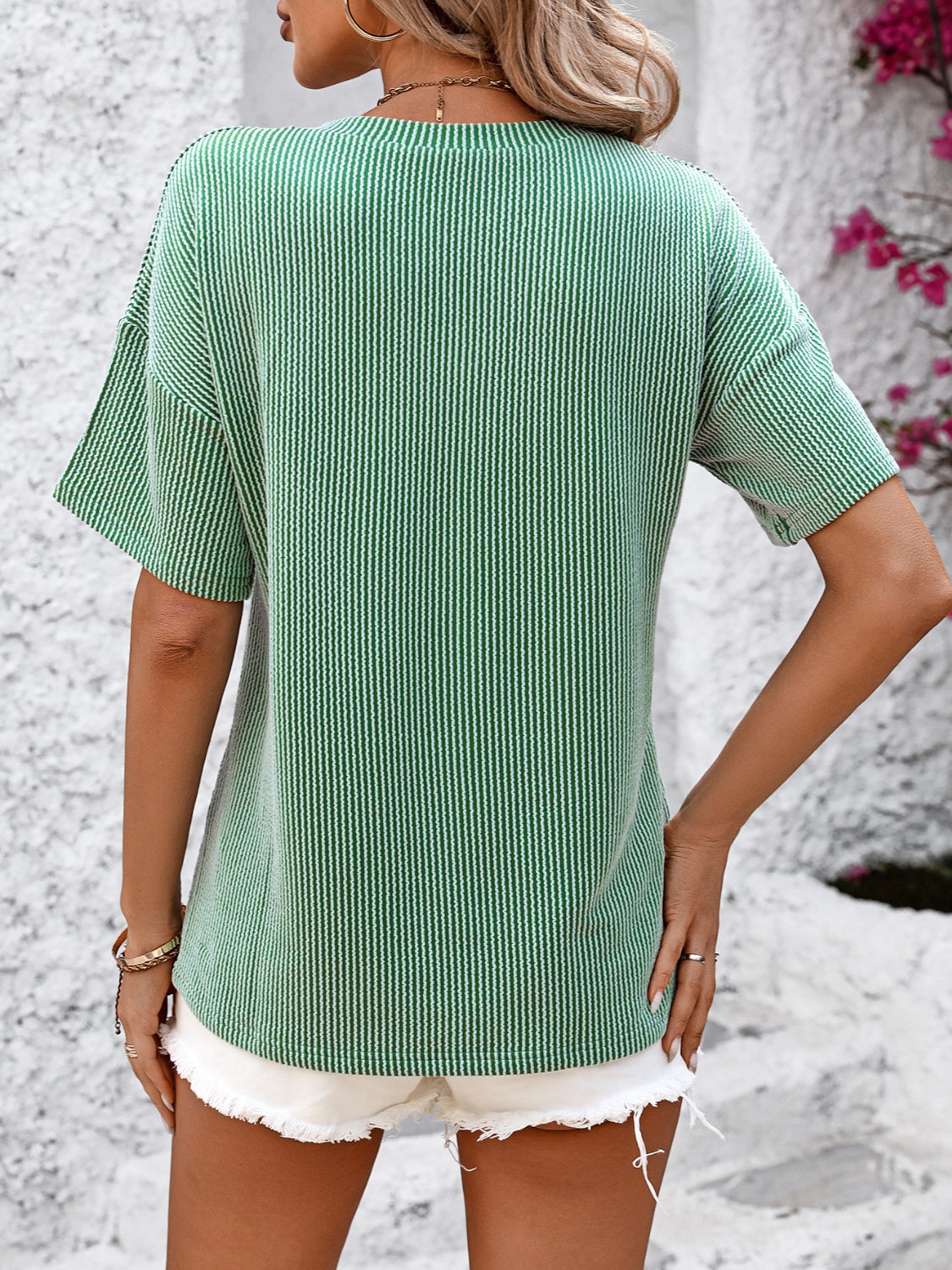 Mid green ribbed V-neck t-shirt with vertical stripes and short sleeves.