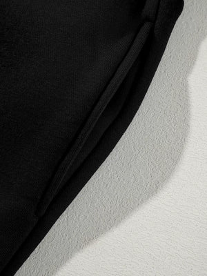 Black cotton joggers with drawstring detail and textured side panel