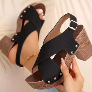 Black crisscross high heel sandals with studs and adjustable strap.
