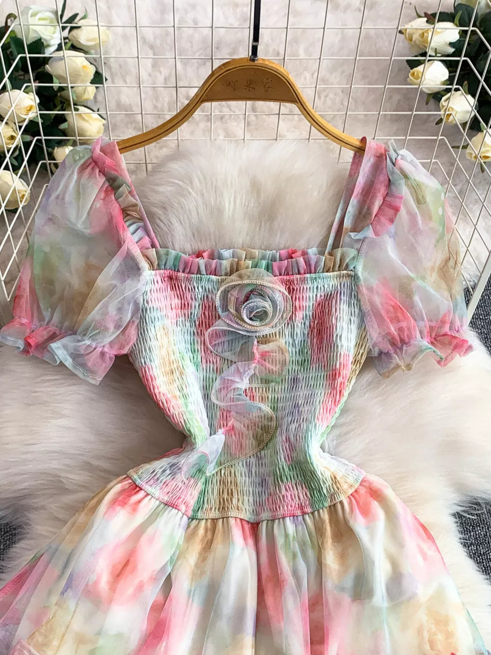 Floral tiered midi dress with smocked bodice, square neck, puff sleeves, and rosette detail.