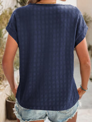 Navy woven texture cap-sleeve top with a relaxed fit, styled with denim shorts.