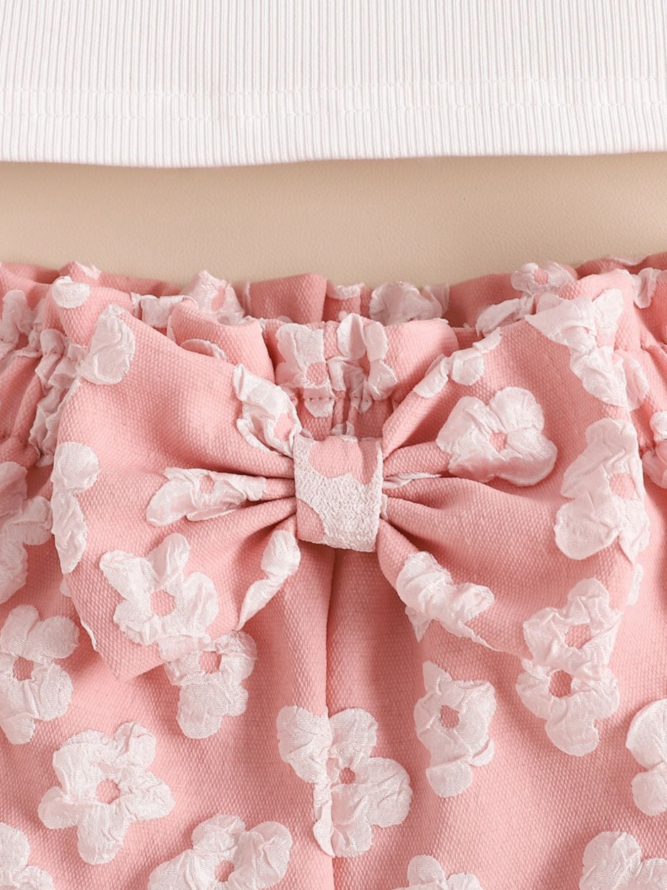 Pink ruffled shorts set with floral texture and bow detail