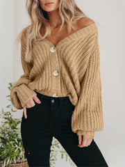 Camel knit cardigan with voluminous sleeves and button front, styled off-shoulder.