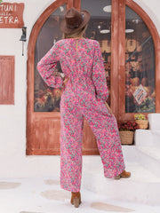 Paisley print wide leg jumpsuit in hot pink with long sleeves and a ruffled front detail.