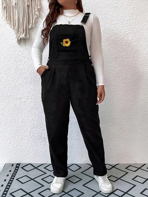 Black corduroy overalls with embroidered sunflower detail and relaxed fit.