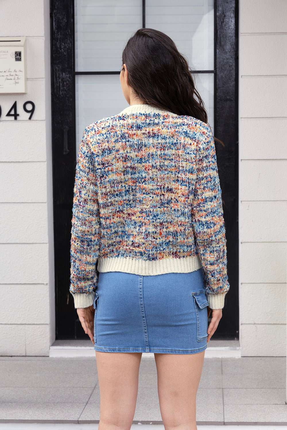 Textured bouclé knit cardigan with cream trim and multicolor flecks.