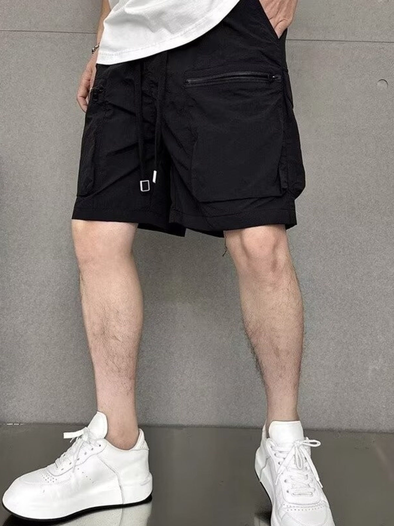 Men's black lightweight multi-pocket cargo shorts with adjustable drawstring and zippered pocket.