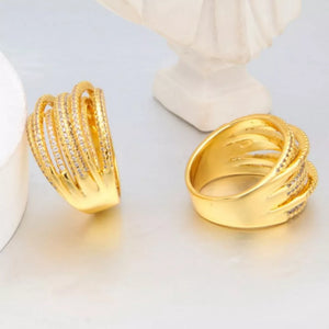 Gold-plated ring with multiple rows of clear stones and textured detailing.