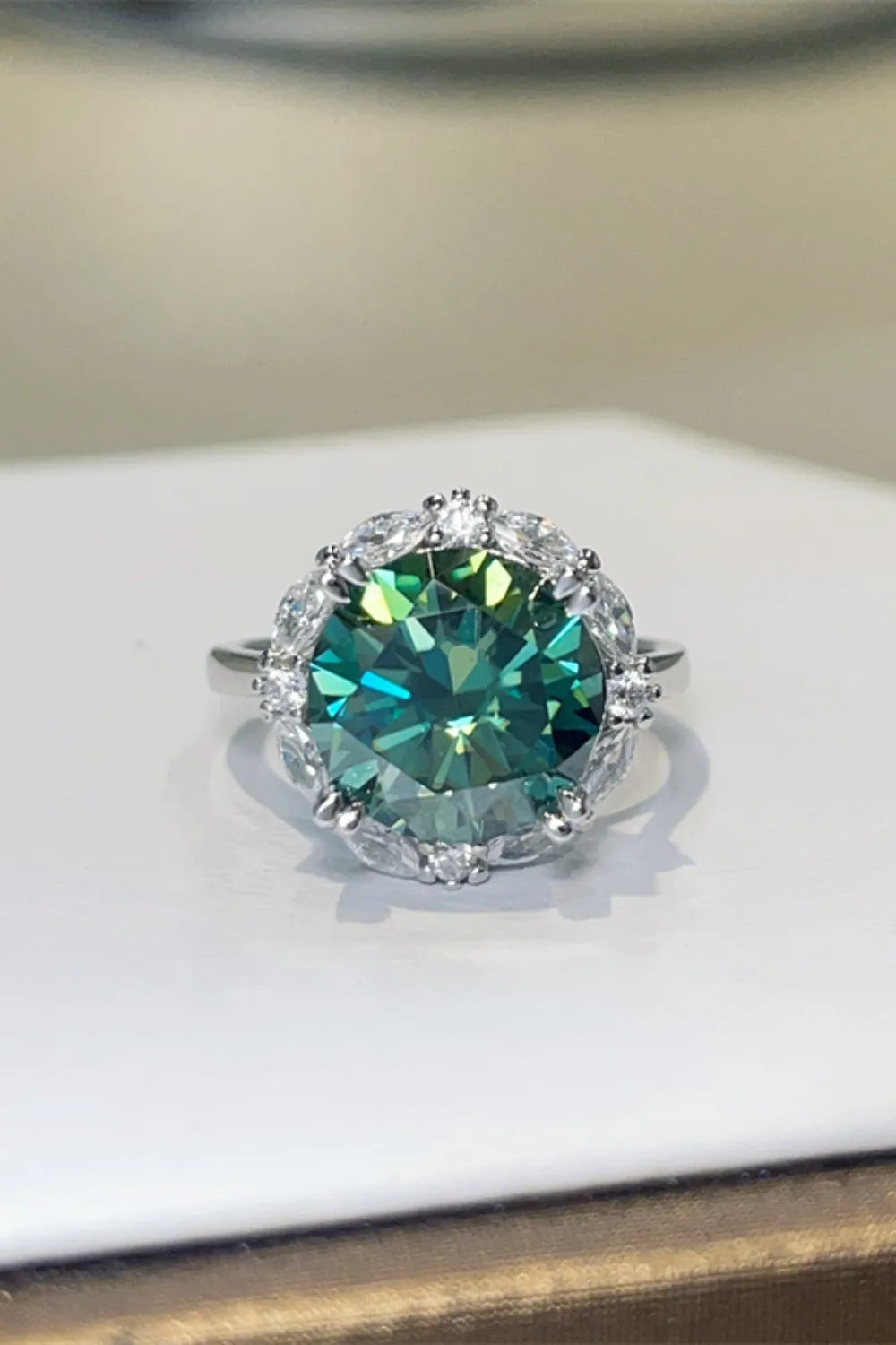 Emerald halo cocktail ring in sterling silver with a dark green center stone.