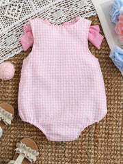 Baby one-piece in blush pink gingham with polka dot bows on sleeves
