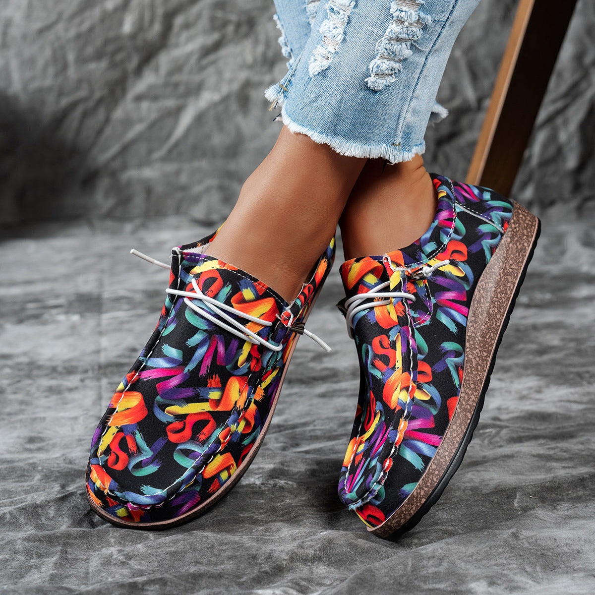 Printed casual slip-on loafers with abstract brushstroke pattern and white laces.
