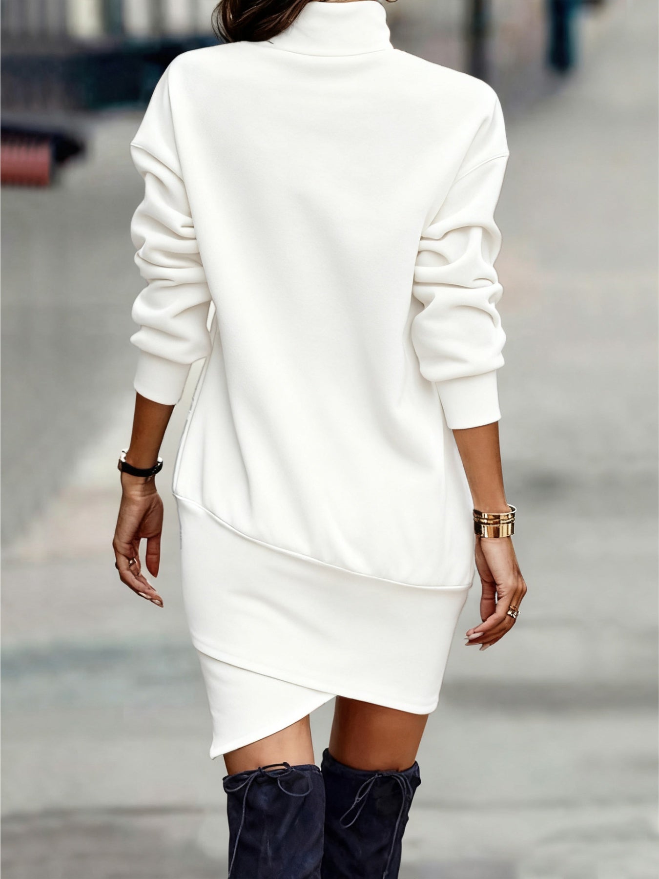White turtleneck mini dress with asymmetrical hem and long sleeves.