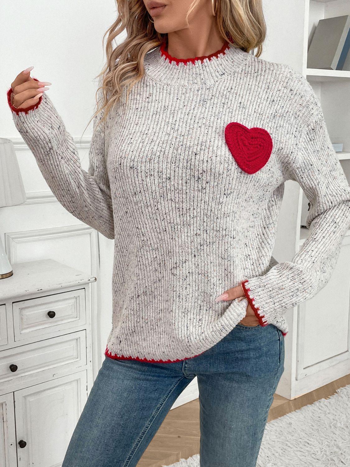 Light gray ribbed knit sweater with red heart appliqué and trim.