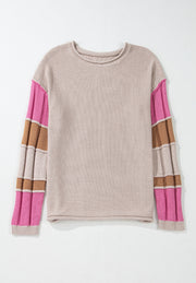 Beige knit sweater with colorblock striped sleeves in pink and brown.