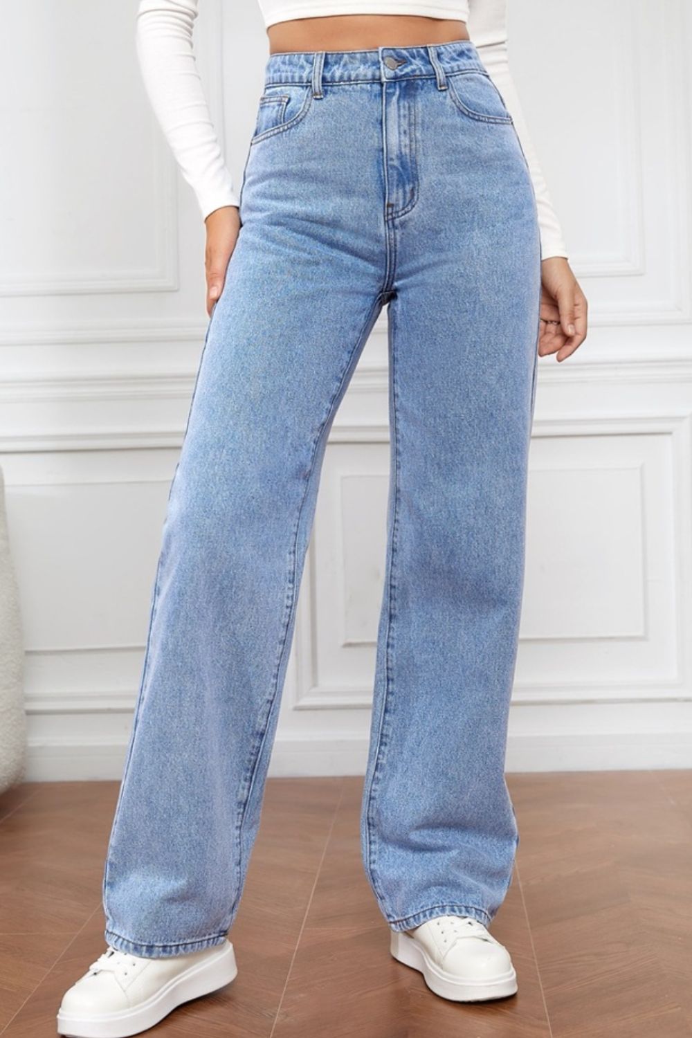 Light blue denim wide-leg jeans with a high rise, shown on a model.
