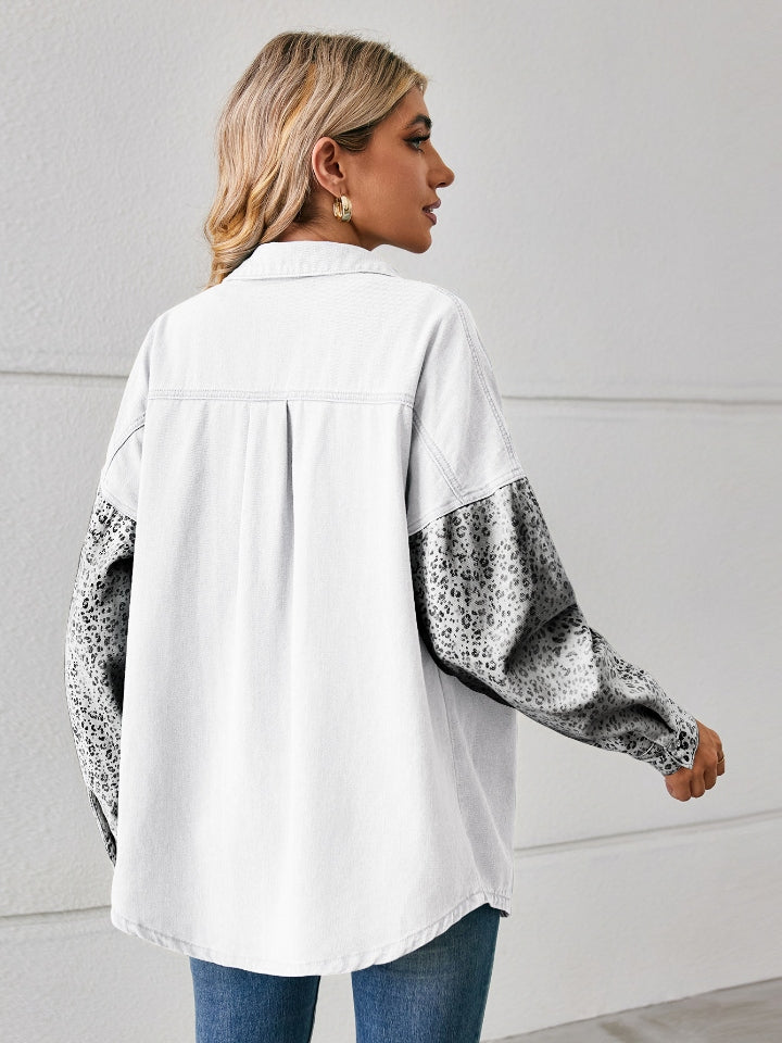 White denim overshirt with leopard print sleeves and buttoned cuffs.