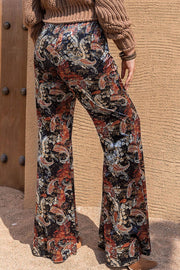 Velvet palazzo trousers in black with a colorful paisley print.
