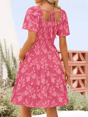 Smocked mini dress in Strawberry with floral embroidery, tiered skirt, puff sleeves, and tie-back square neck.