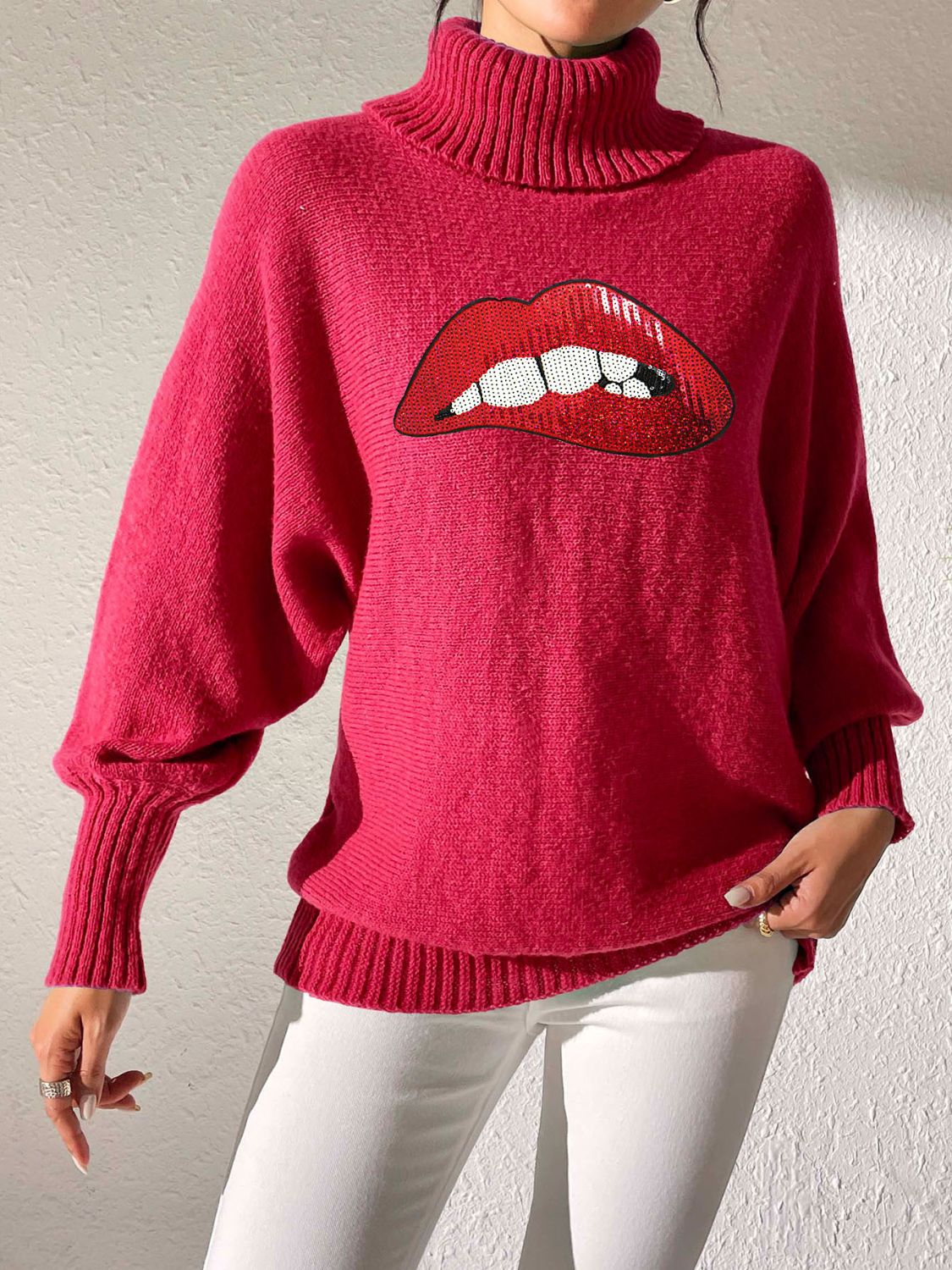Pink turtleneck sweater with sequin red lips graphic and balloon sleeves.