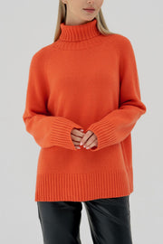 Orange cashmere turtleneck sweater with raglan sleeves and ribbed cuffs and hem.