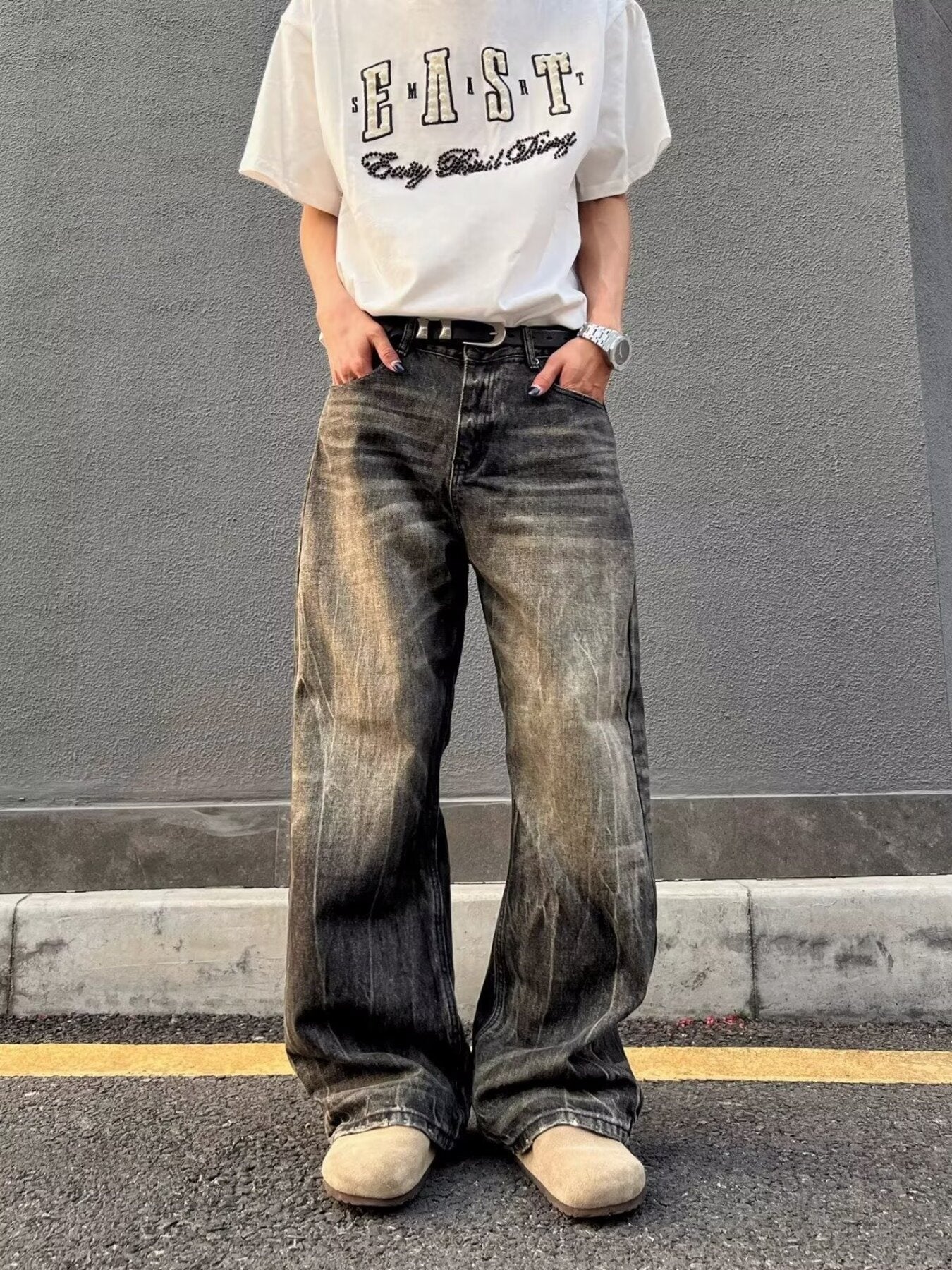 Men's vintage wash wide-leg jeans in relaxed fit, featuring distressed details and a faded black color.