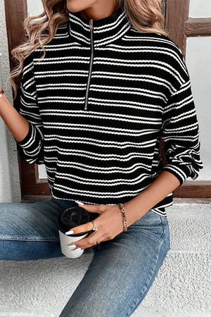 Black and white striped ribbed half-zip pullover sweater with a mock neck.