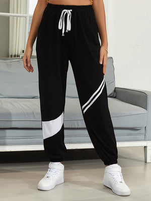 Black joggers with white diagonal panel details and drawstring waist.