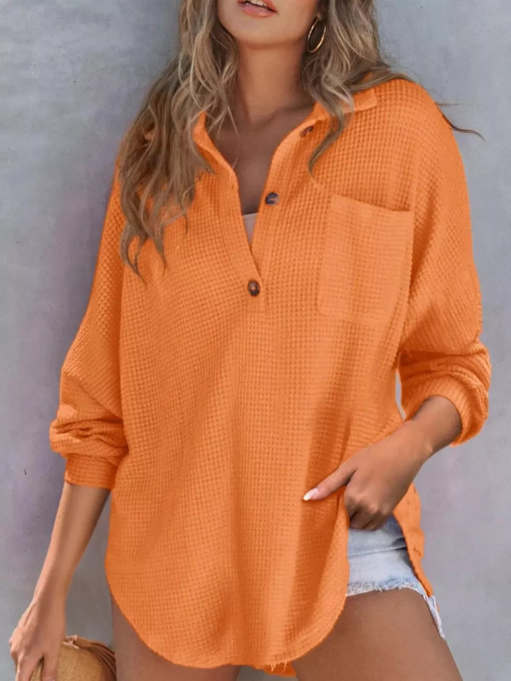 Orange waffle-knit Henley tee with button placket and chest pocket, long sleeves.