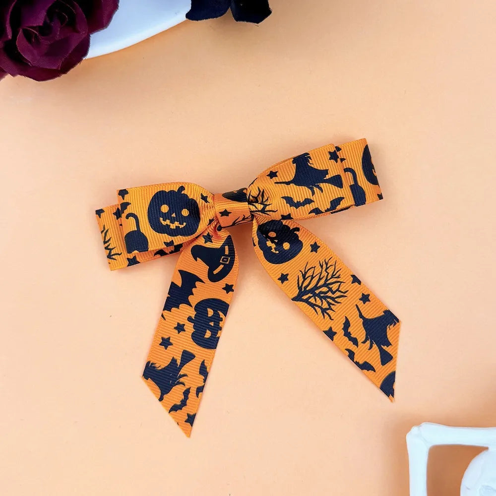 Tangerine Halloween print bow hair clip with pumpkins, bats, and witches.
