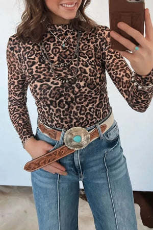 Leopard print high neck slim fit long sleeve shirt with layered necklaces and jeans.