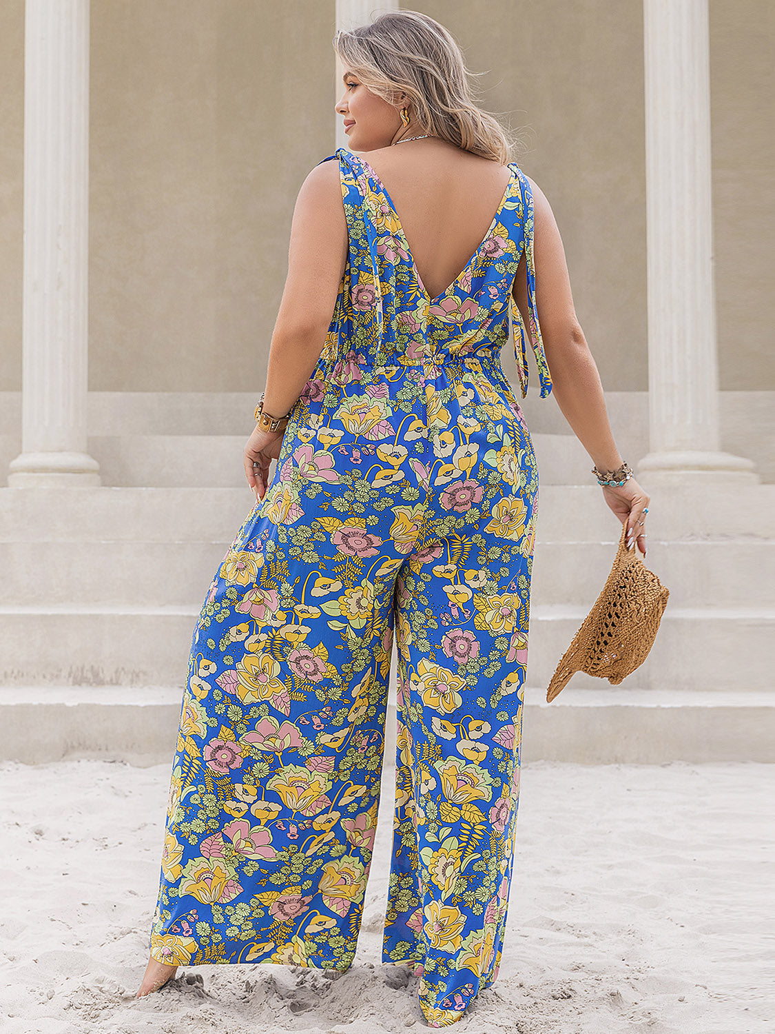 Blue floral tie-shoulder wide-leg jumpsuit with a V-neck back and cinched waist.