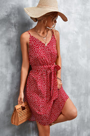 Red daisy print slip dress with tie waist and spaghetti straps.