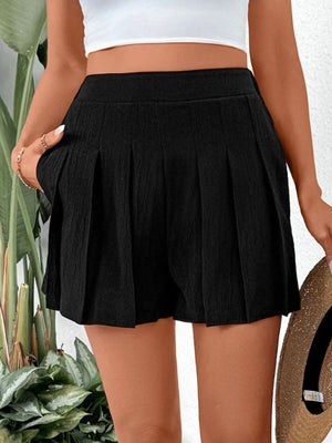Black pleated shorts with pockets and a textured fabric.