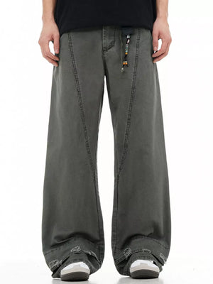 Men's wide-leg denim trousers in dark grey with distressed hem detail and beaded drawstring.