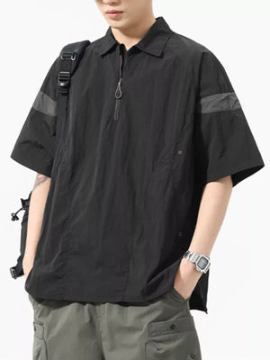 Black quarter-zip polo shirt with short sleeves, a chest pocket, and contrasting arm details.