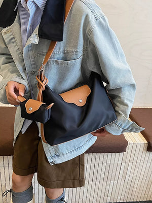 Black canvas hobo bag with tan trim and matching coin purse.