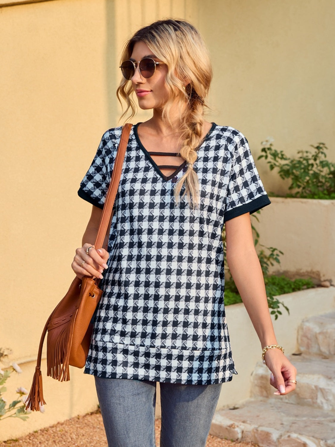 Houndstooth tunic top with cutout neckline and short sleeves.
