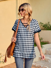 Houndstooth tunic top with cutout neckline and short sleeves.