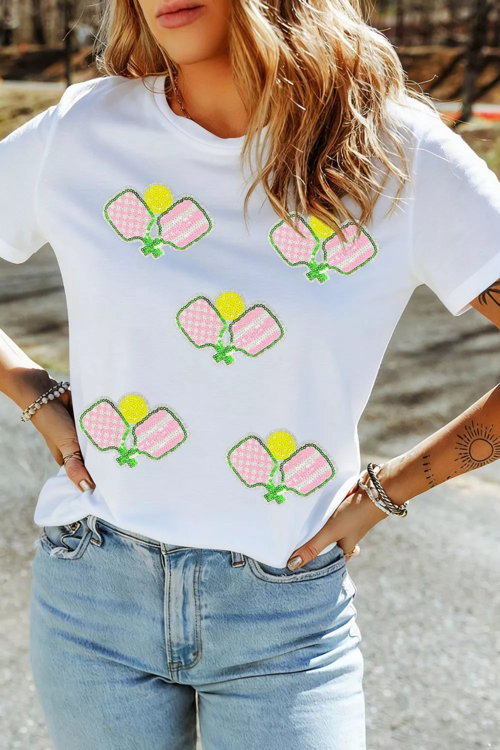 White cotton t-shirt with playful sequin pickleball applique detail.