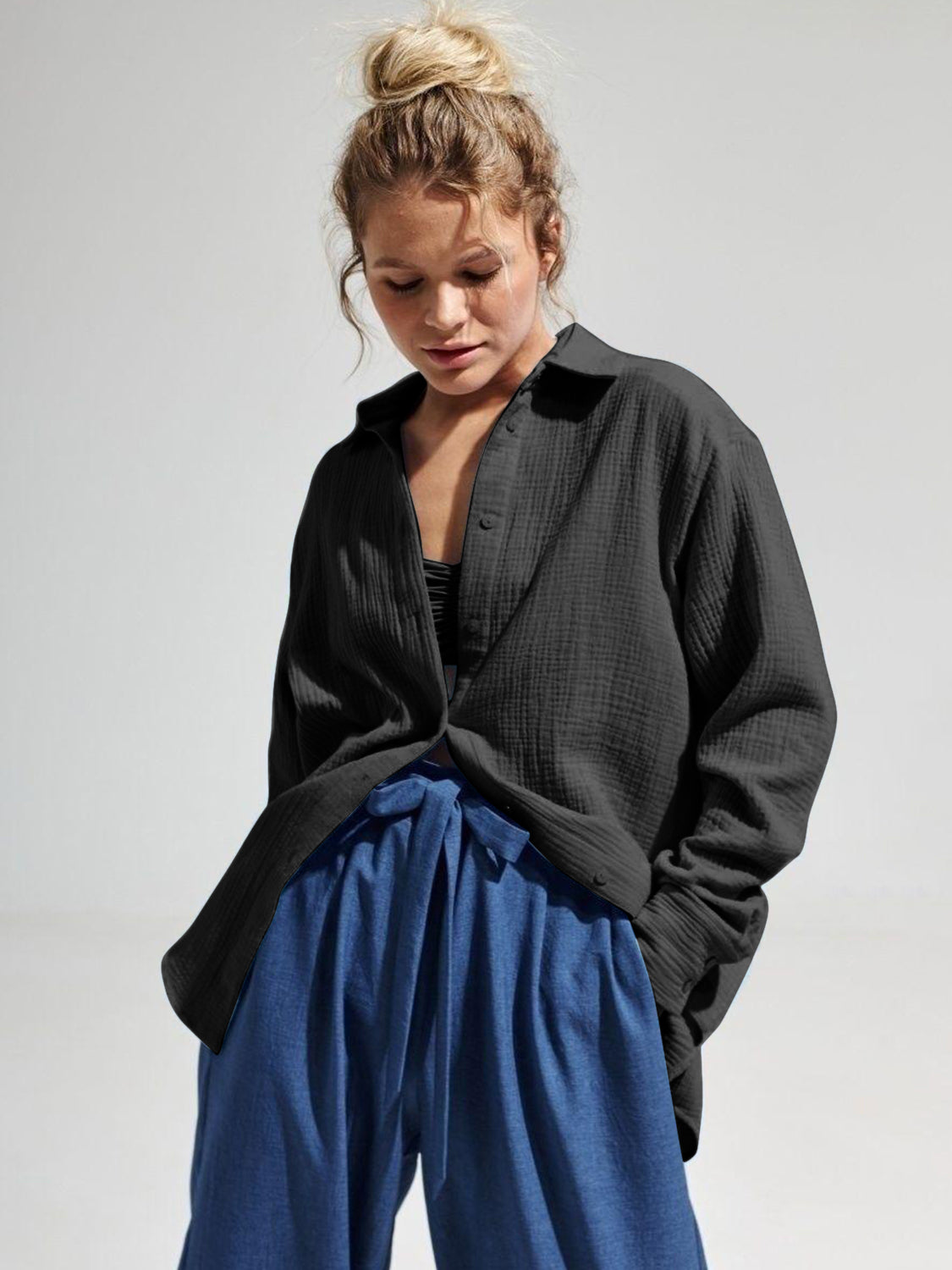 Black textured cotton overshirt with relaxed fit and button front, styled open over a bralette.