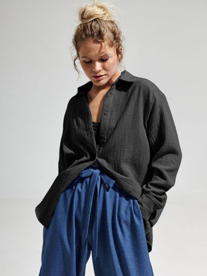 Black textured cotton overshirt with relaxed fit and button front, styled open over a bralette.