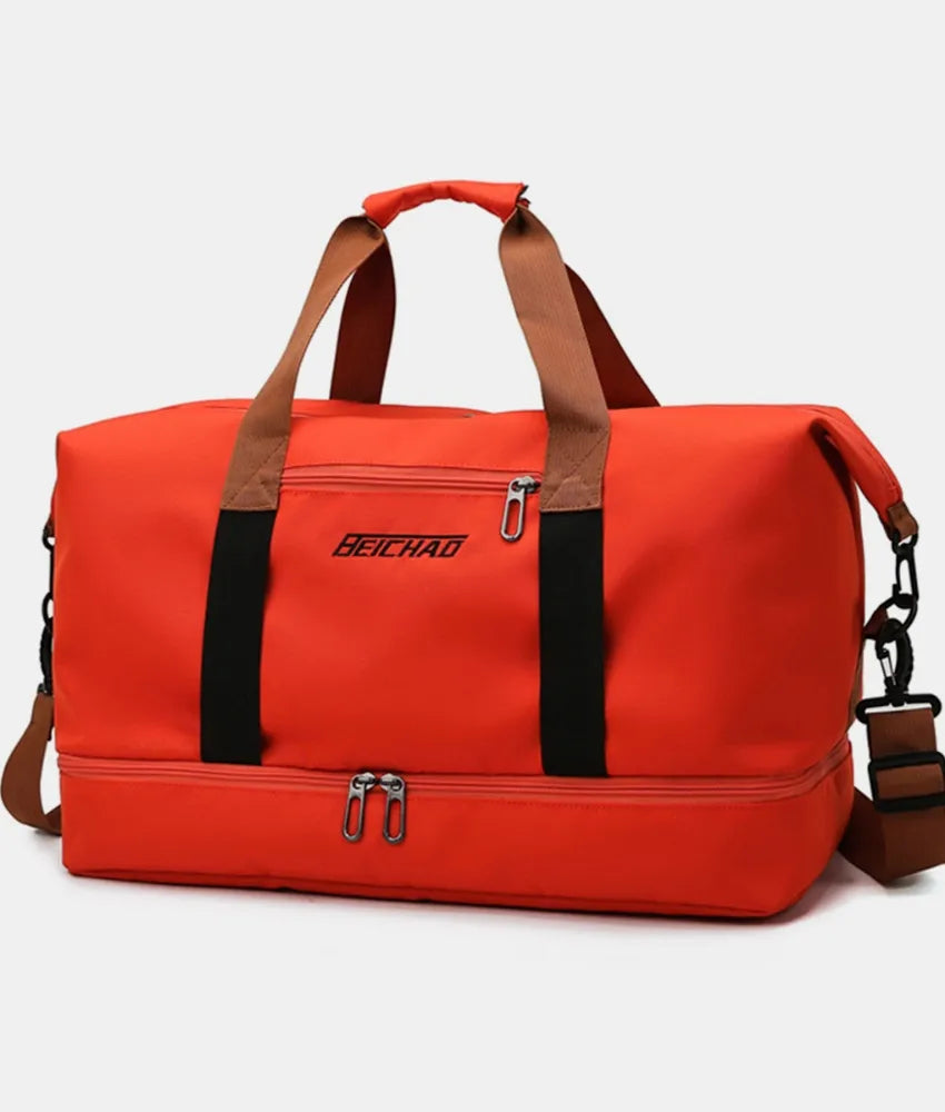 Orange dual-compartment weekender bag with black and brown contrast straps and zippers.