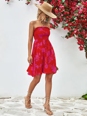 Smocked bandeau mini dress in red with pink floral print, drawstring waist, and A-line skirt.