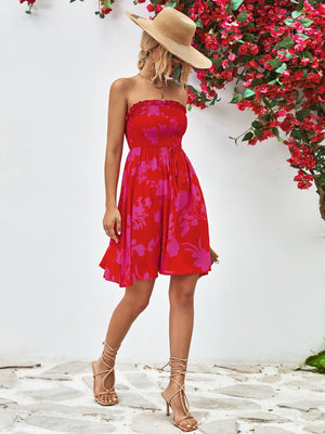 Smocked bandeau mini dress in red with pink floral print, drawstring waist, and A-line skirt.