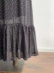 Black floral maxi dress with tiered ruffle hem and sheer overlay.