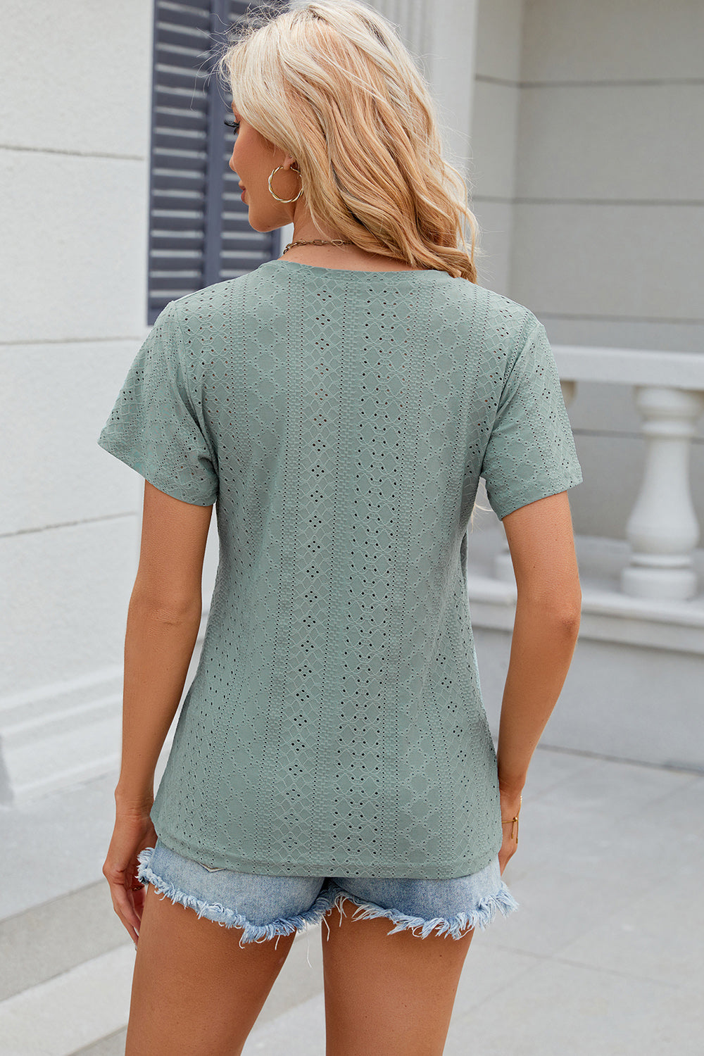 Light green eyelet wrap V-neck top with short sleeves and a casual cut.