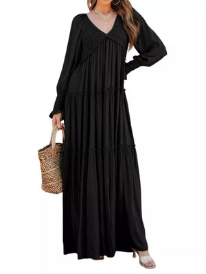 Black smocked V-neck tiered maxi dress with long sleeves and ruffled cuffs.